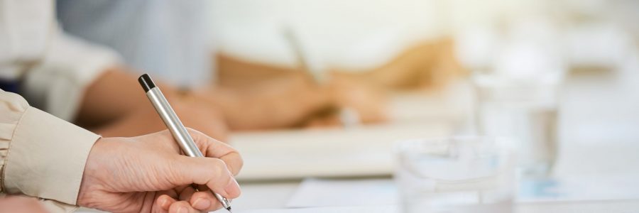 Hand of business lady signing agreement at meeting